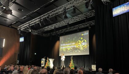 Festveranstaltung mit Bühne, Redner und Publikum, Willkommen zur Jubiläumsveranstaltung 30 Jahre, Bühnenaufbau mit Trussing und Beleuchtung