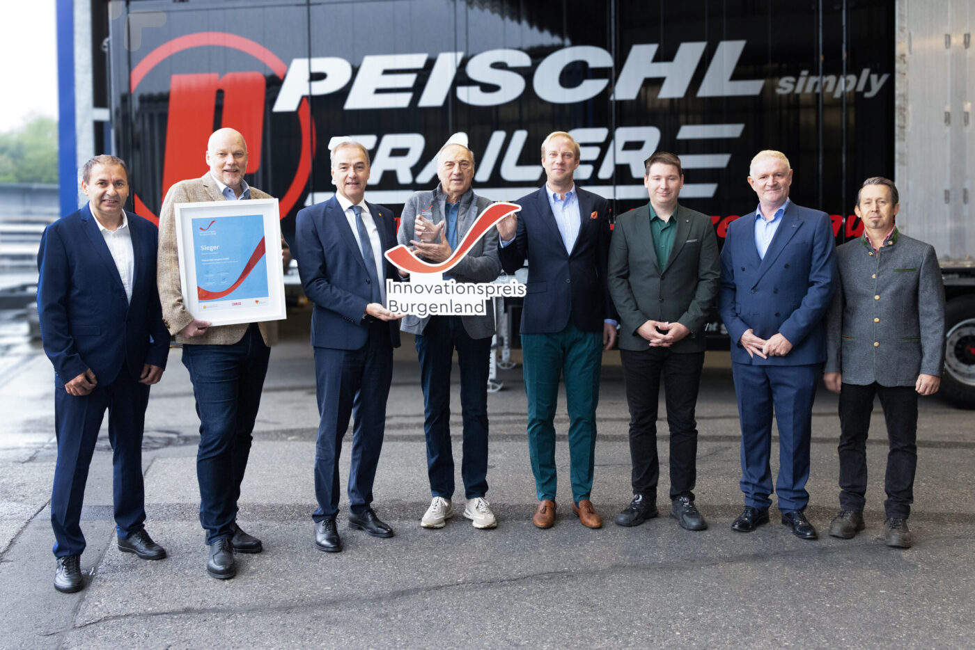 Peischl Trailer gewinnt Innovationspreis Burgenland, Gruppenfoto mit acht Personen vor Firmengebäude. (_r6a9125_innovationspreis_wab)