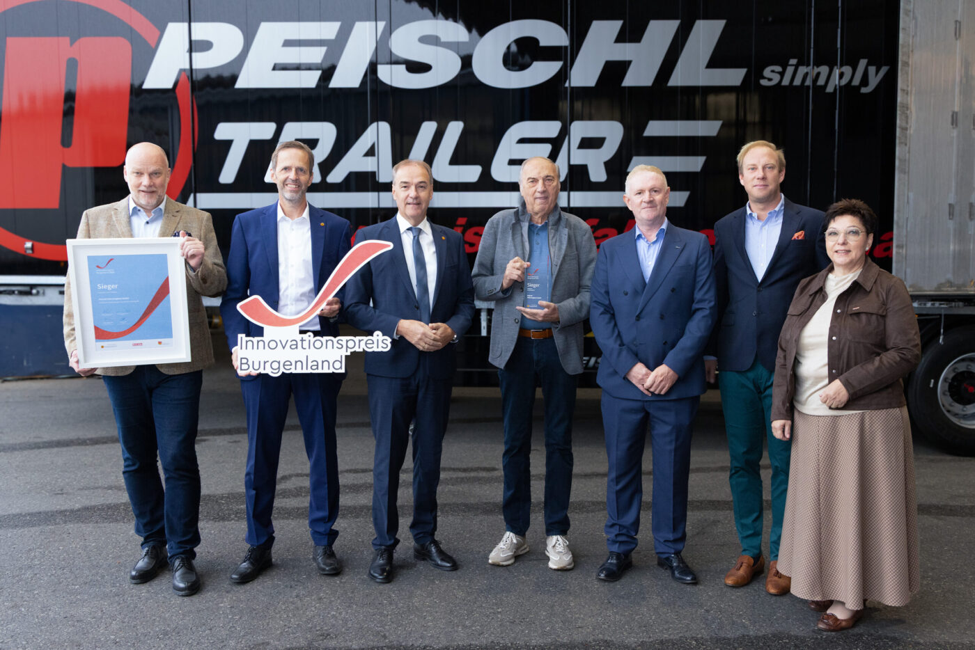 Peischl Trailerwerk Innovationspreis Burgenland Gewinner mit Auszeichnung vor Firmengebäude (_r6a9161_innovationspreis_wab)