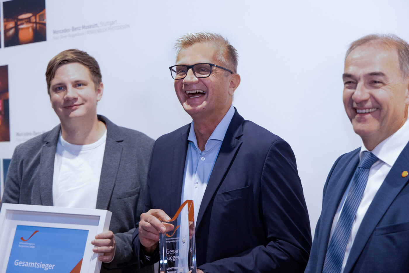 Drei Geschäftsmänner präsentieren stolz einen Award Gesamtsieger bei einer Preisverleihung, Auszeichnungsveranstaltung. (_r6a9256_innovationspreis_wab)