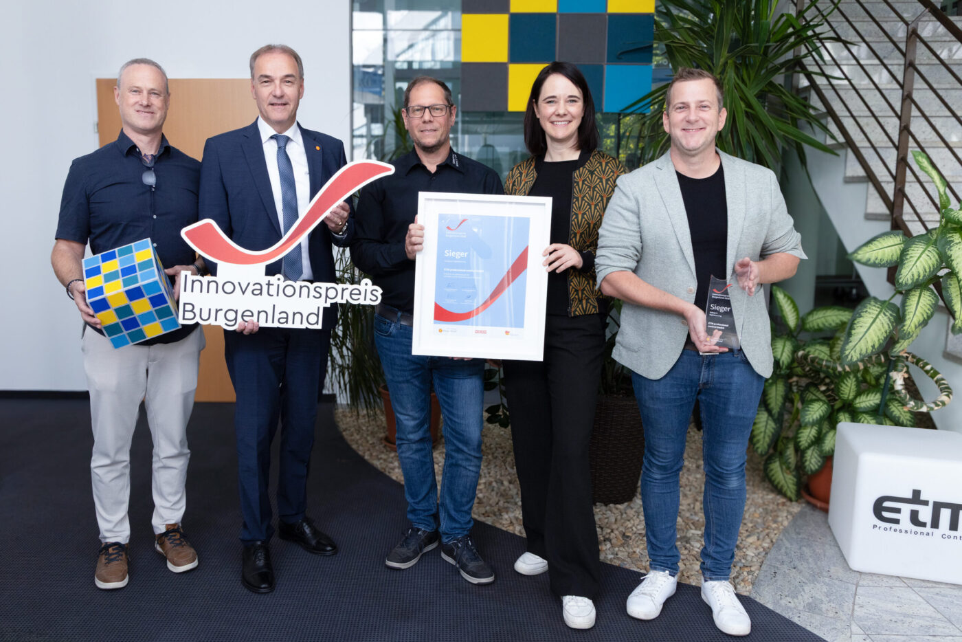 Innovationspreis Burgenland Sieger: Fünf Personen präsentieren Urkunde und Award in modernem Büro mit Pflanze. (_r6a9402_innovationspreis_wab)